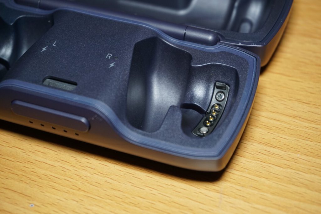 把耳機放置在收納盒中，金屬端口接觸到耳機就能充電。